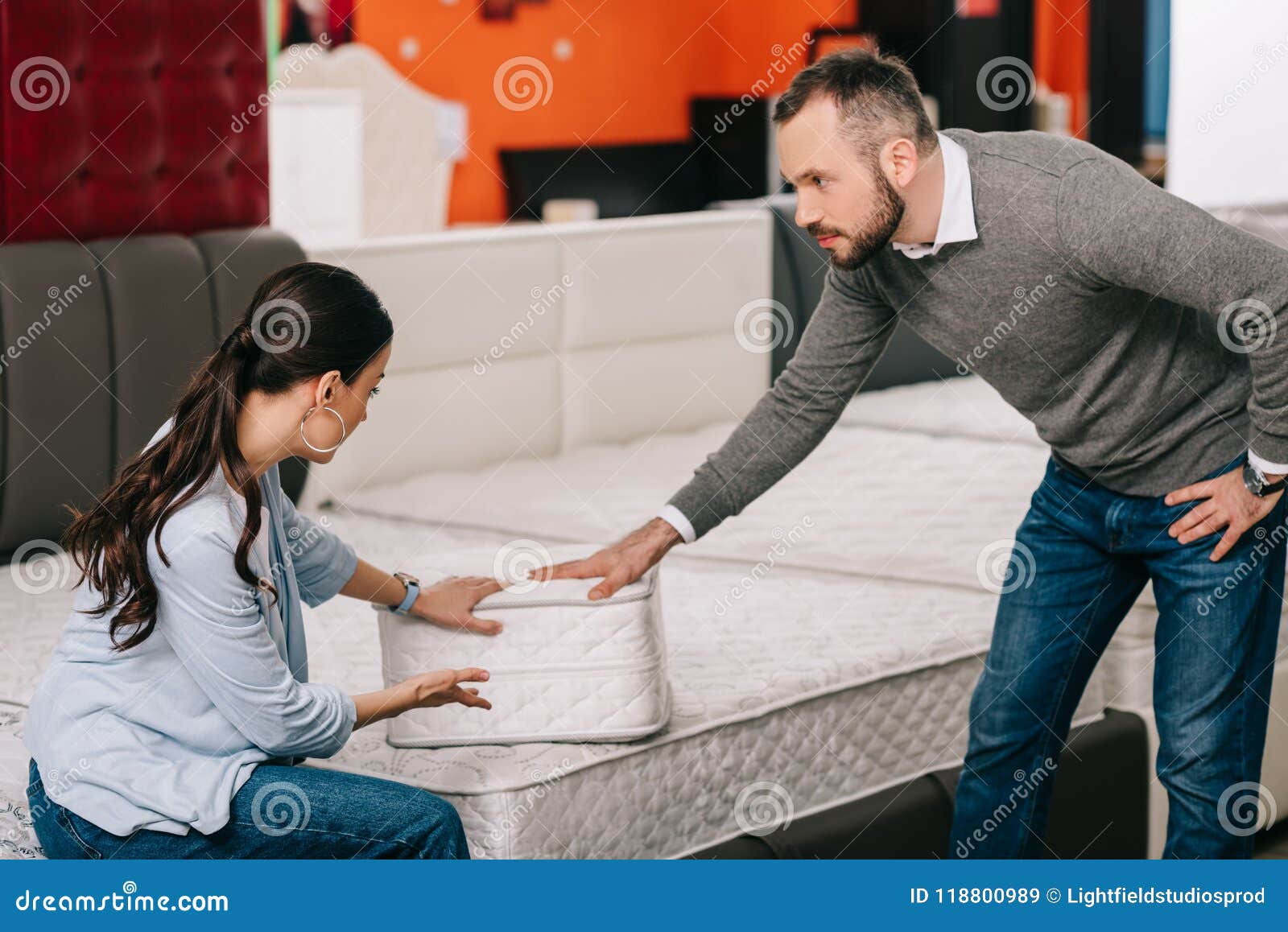 couple choosing folding mattress together in furniture store