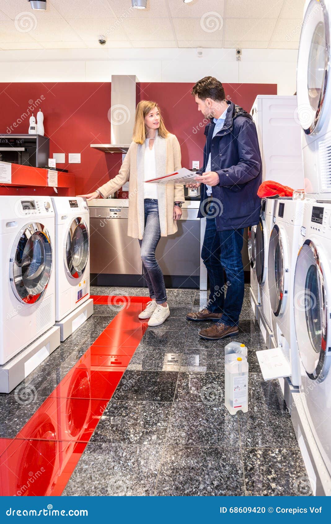 couple choosing washing machine in hypermarket