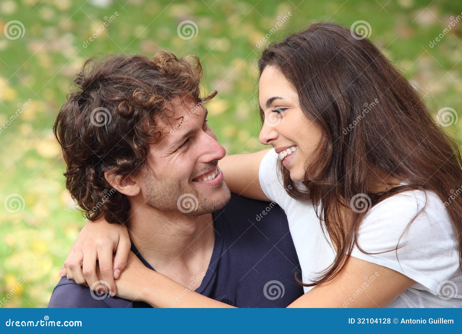 couple cuddling and flirting in a park
