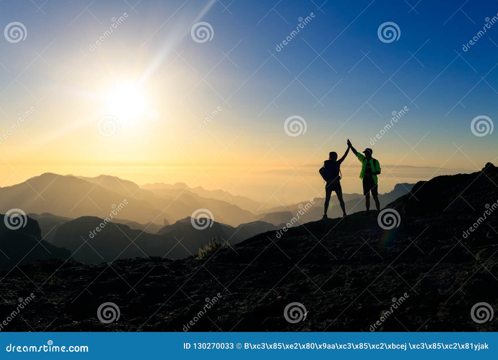 couple hikers celebrating success concept in mountains