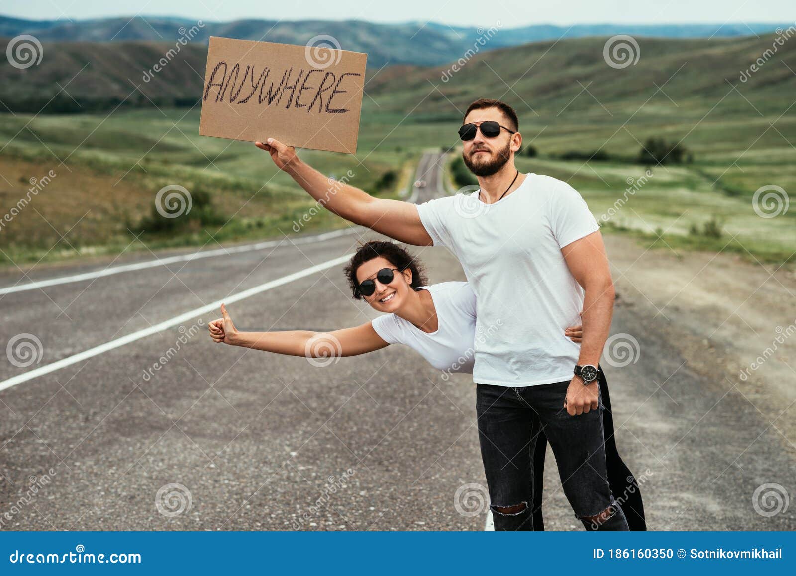 a couple hitchhiking. a man and a woman catch a car by the road. a young couple votes on the road.