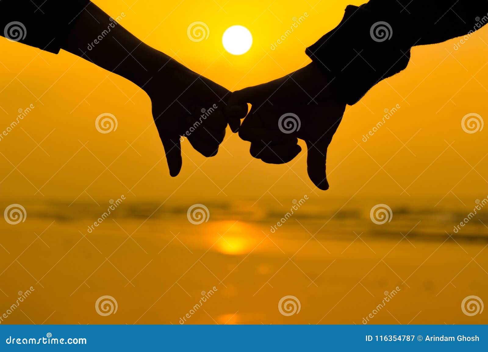 Couple Holding Each Other Hands Using Little Pinky Finger In Background Of Sunrise At The Beach