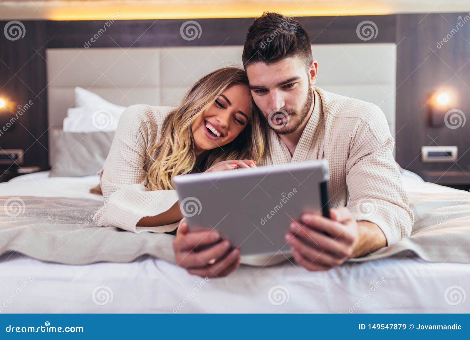 Couple In Hotel Room Reading Room Service Menu Together Stock Image