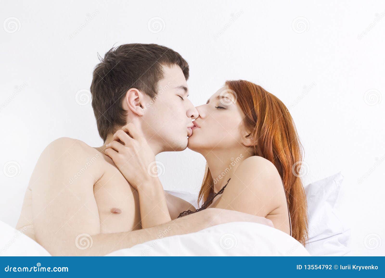 Girl kissing boy on bed