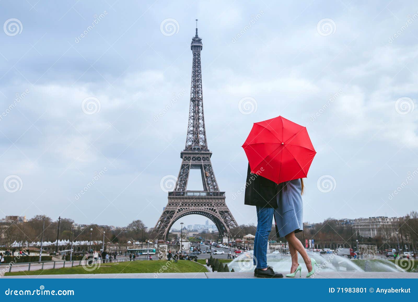 couple kissing behind red umbrella in paris