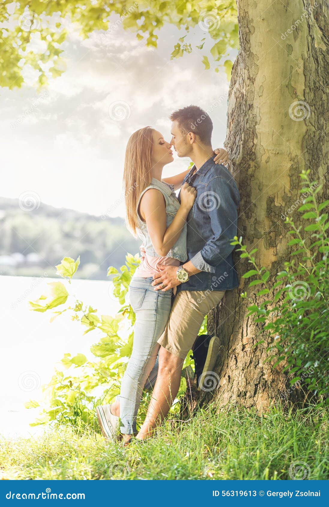 couple in love on the lake, beneath the trees, kissing