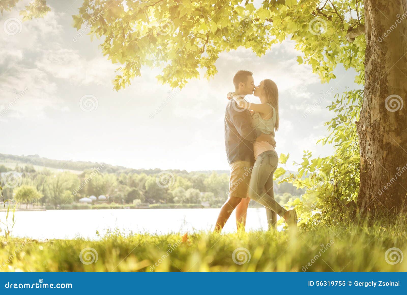 couple in love on the lake, beneath the trees, kissing