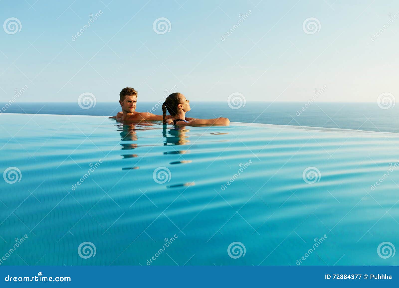 couple in love in luxury resort pool on romantic summer vacation