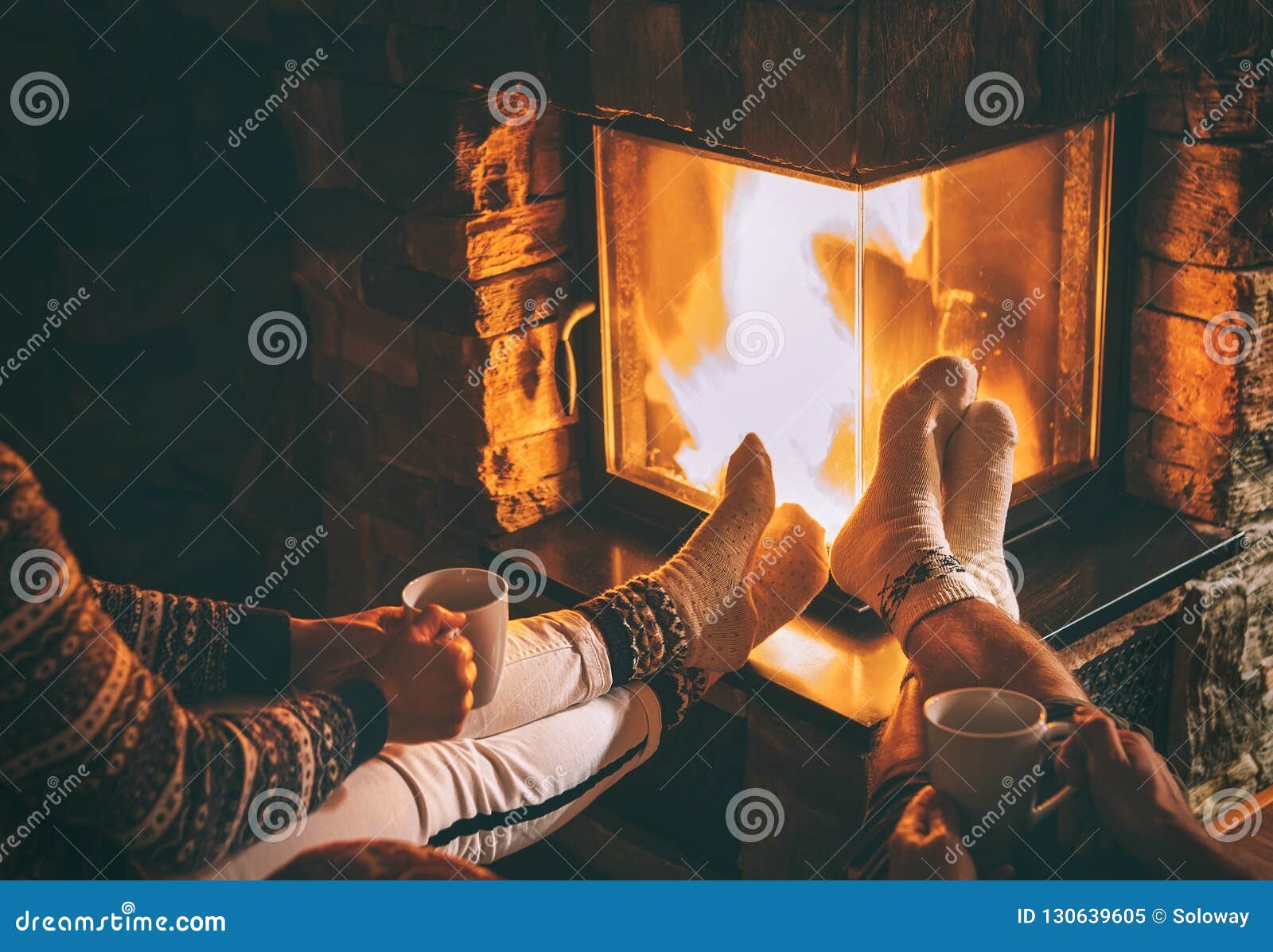 couple in love sitting near fireplace. legs in warm socks close