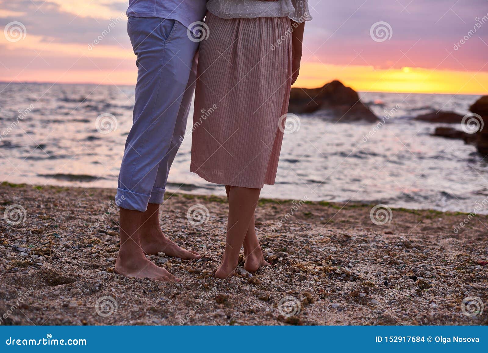 Couple In Love Are Standing And Meeting Sunrise At The Beach In Ocean