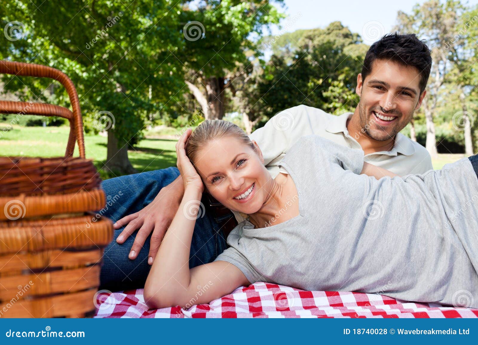 Couple picnicking in the park and looking the camera