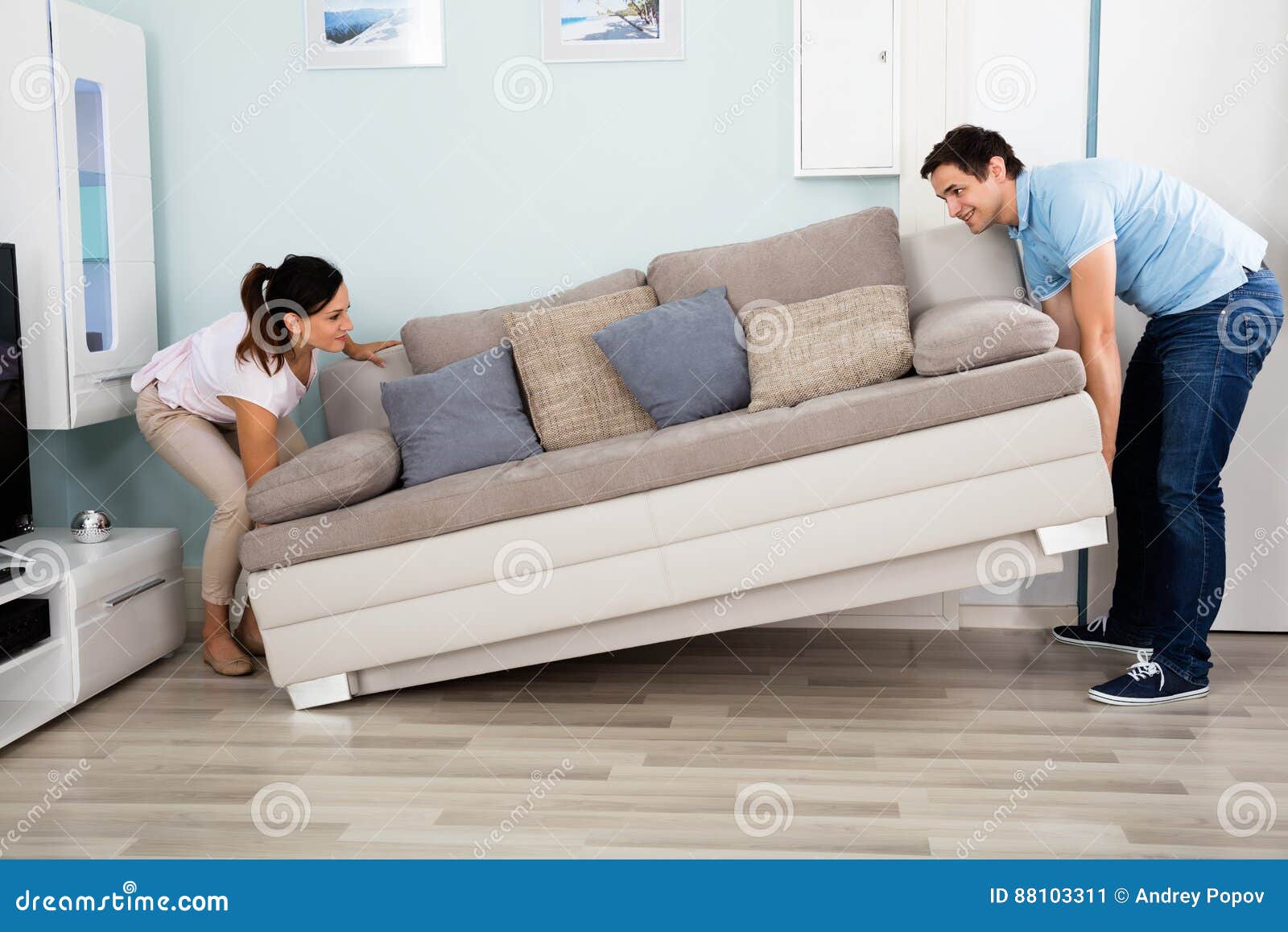 couple placing sofa in living room