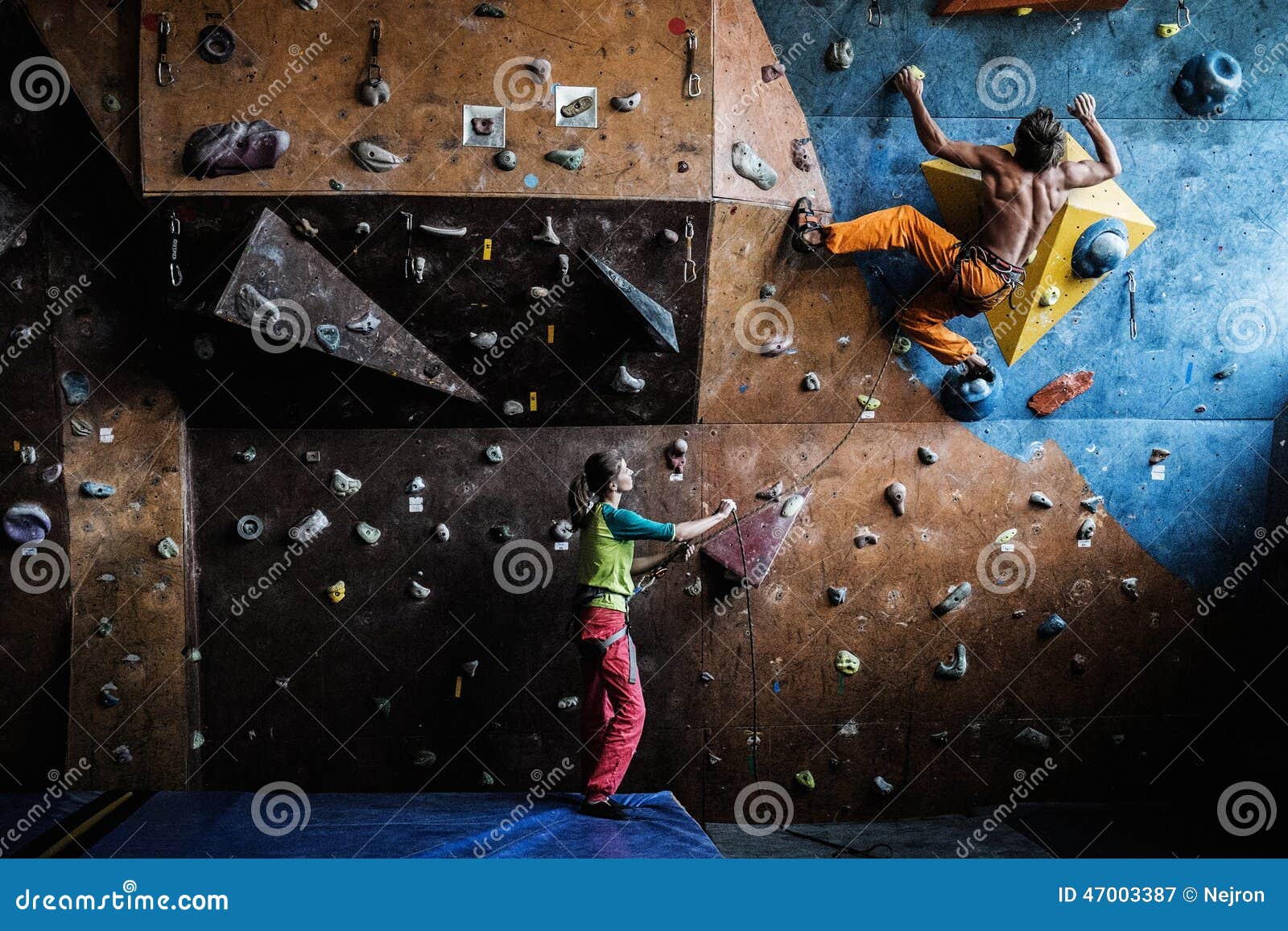 couple practicing rock-climbing on a rock wall