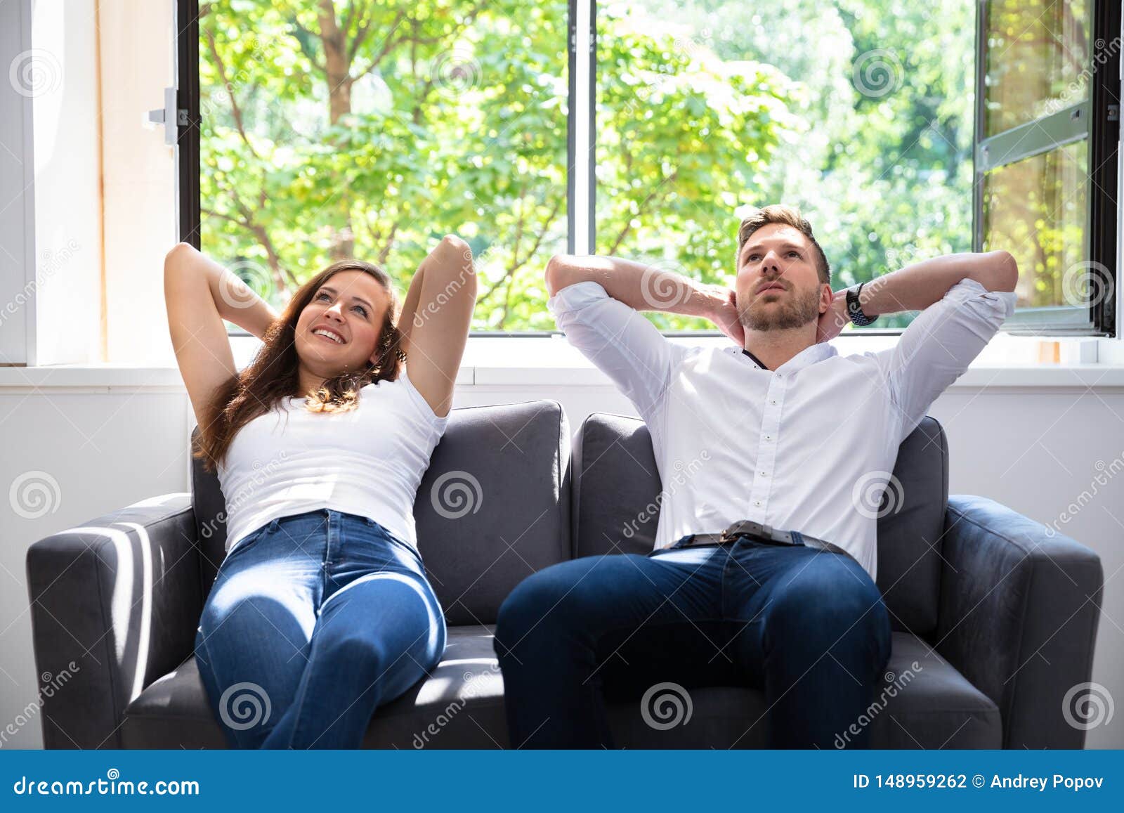 Couple Relaxing on Sofa stock photo. Image of people 148959262