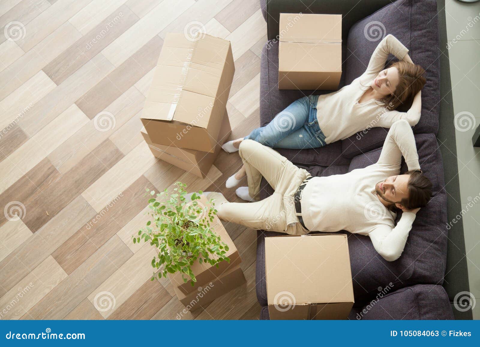 relaxed couple resting on couch after moving in new home