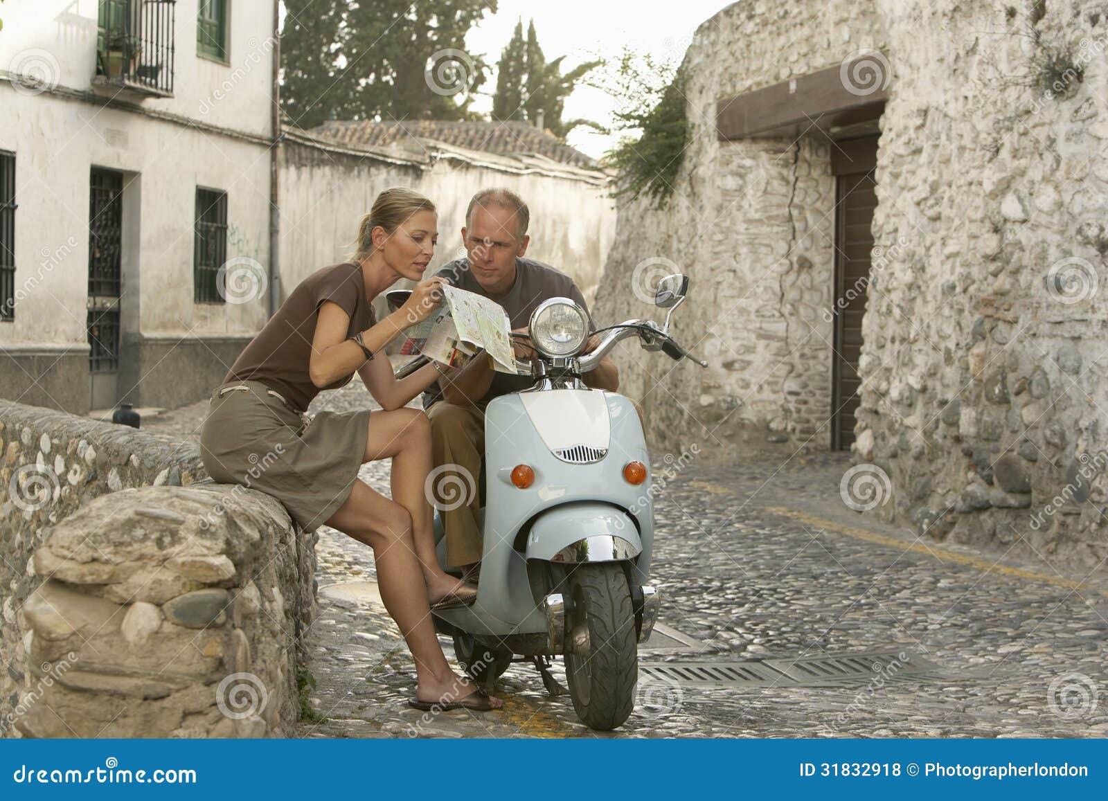 couple with scooter reading map in granada