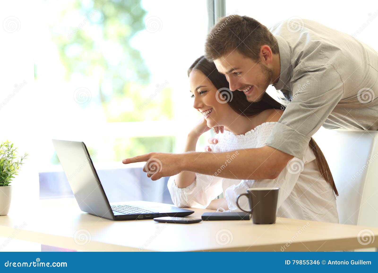 couple searching online in a laptop at home