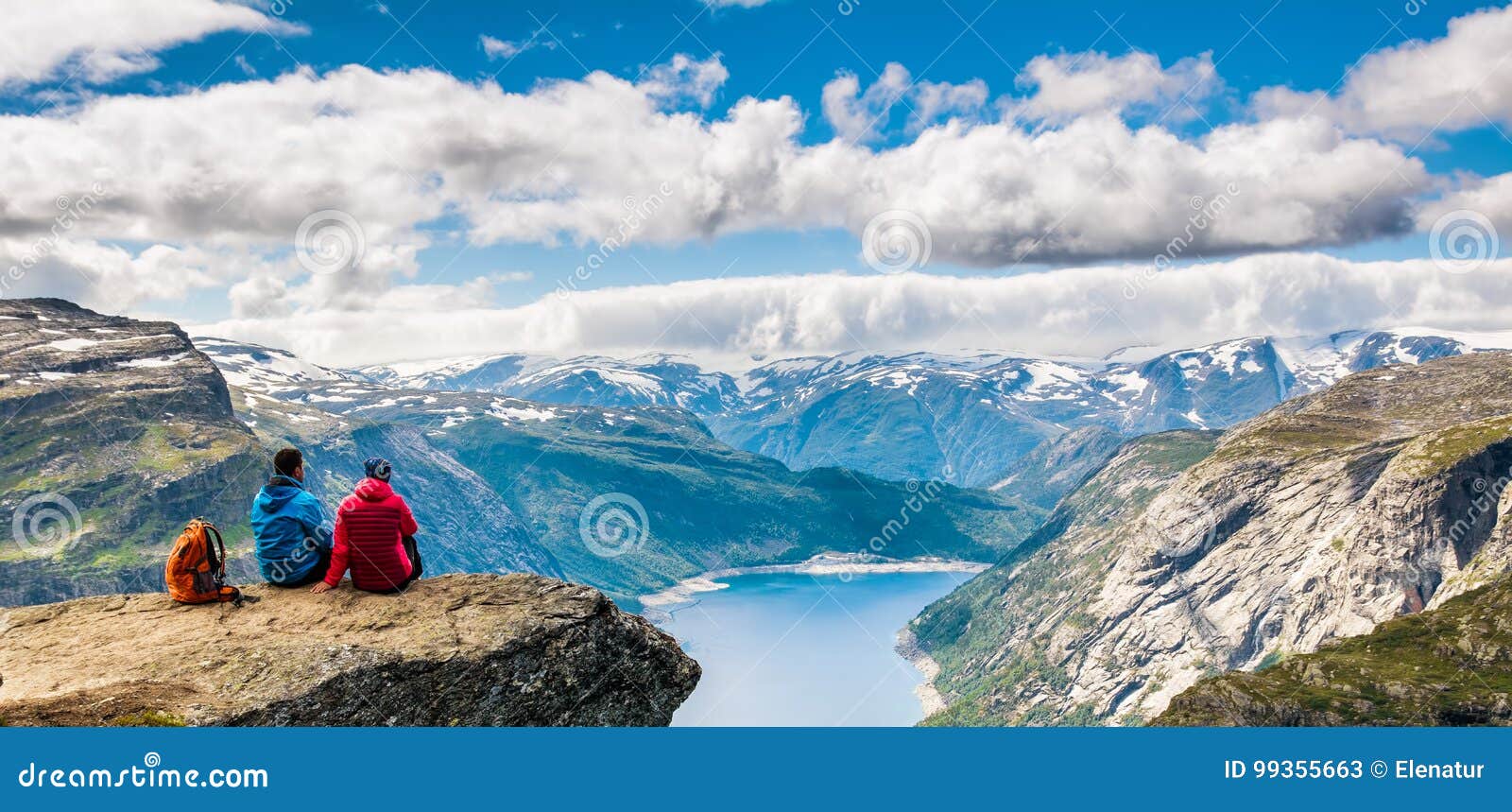 couple sitting against amazing nature view on the way to trolltunga. location: scandinavian