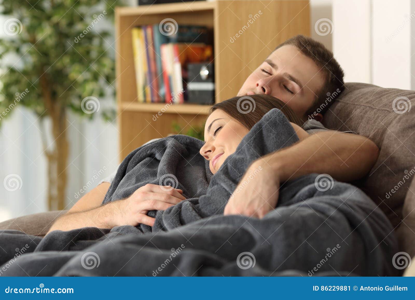 couple sleeping together on a couch at home