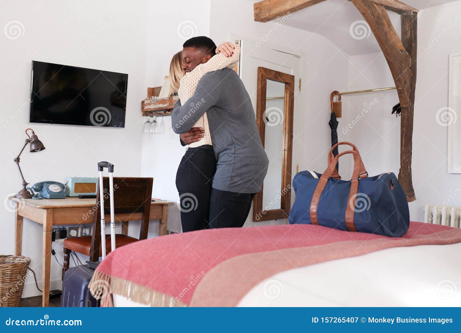 Couple Spending Romantic Weekend Away Hugging In Hotel Room Stock Image