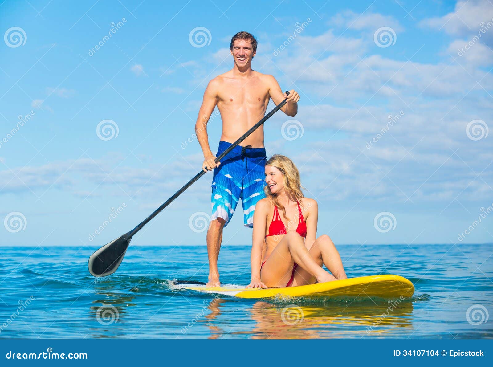 couple stand up paddle surfing in hawaii