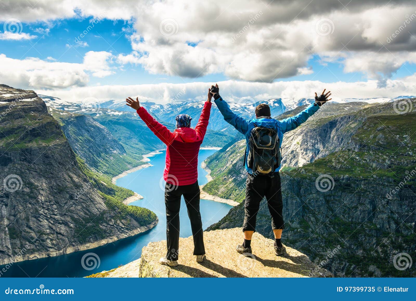 couple standing against amazing nature view on the way to trolltunga. location: scandinavian mountains, norway, stavanger. artist