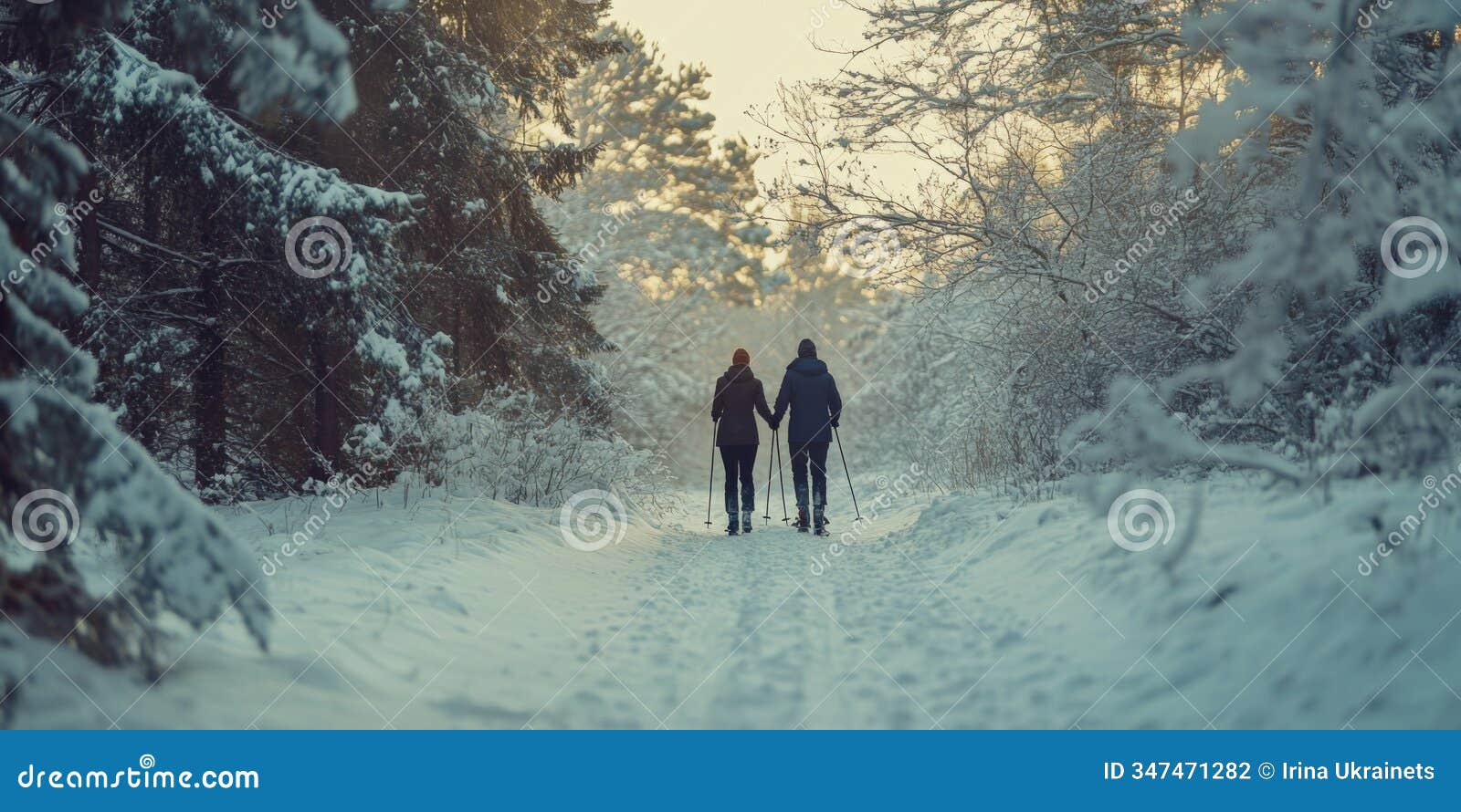 a couple strolls hand in hand along a snowy path surrounded by winter trees. the soft light creates a romantic mood