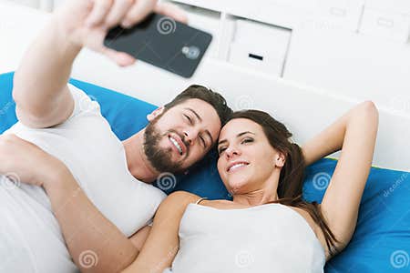 Couple Taking Selfies in Bed Stock Image - Image of enjoying, bedding