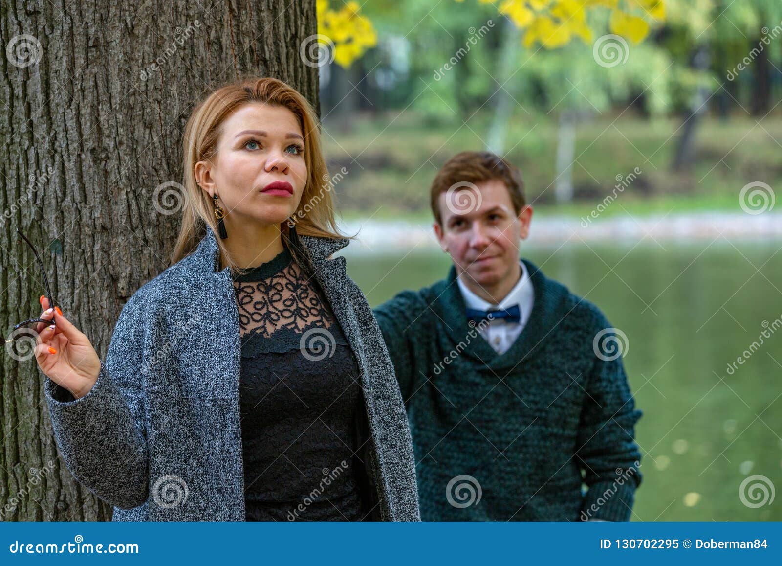 Couple Talking Seriously Outdoors In A Park With A Green Background