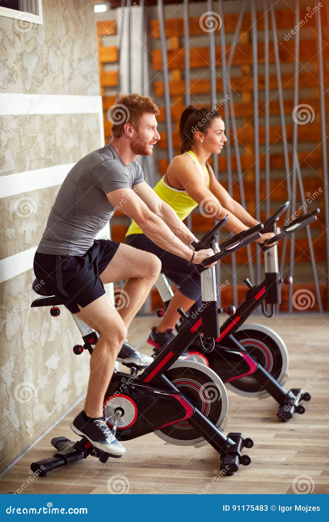 couple trains on bike in gym