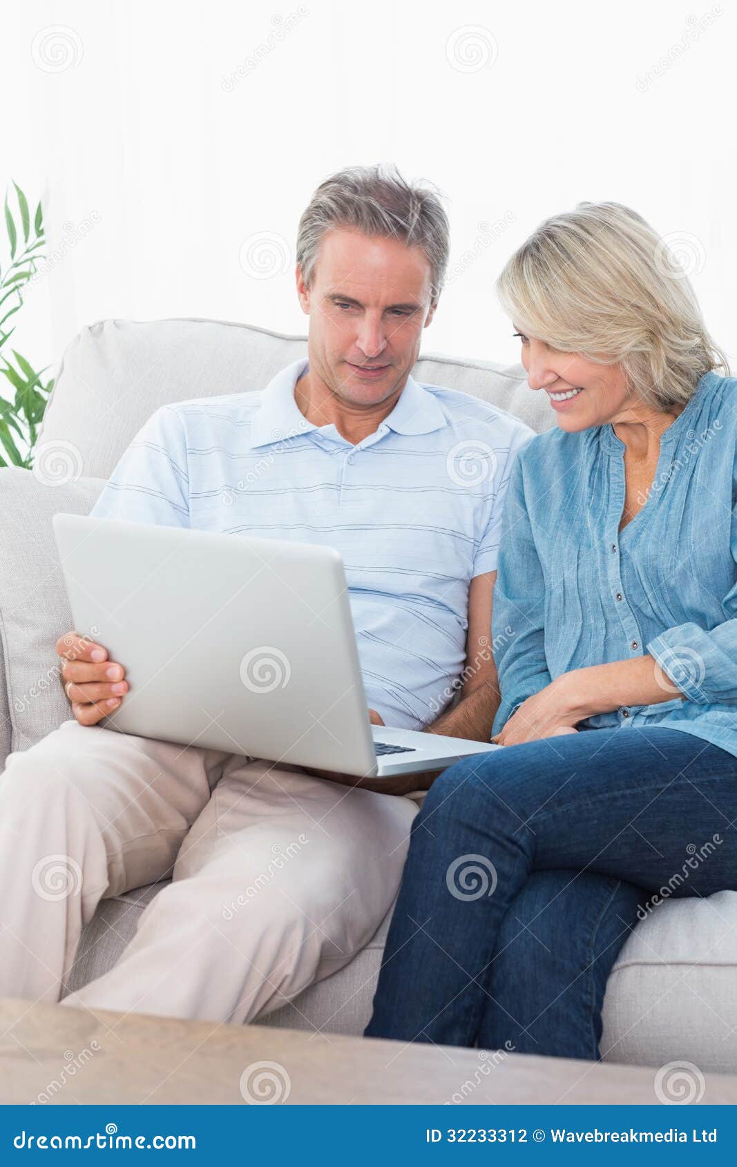 Couple Using Laptop Together on the Couch Stock Photo - Image of ...