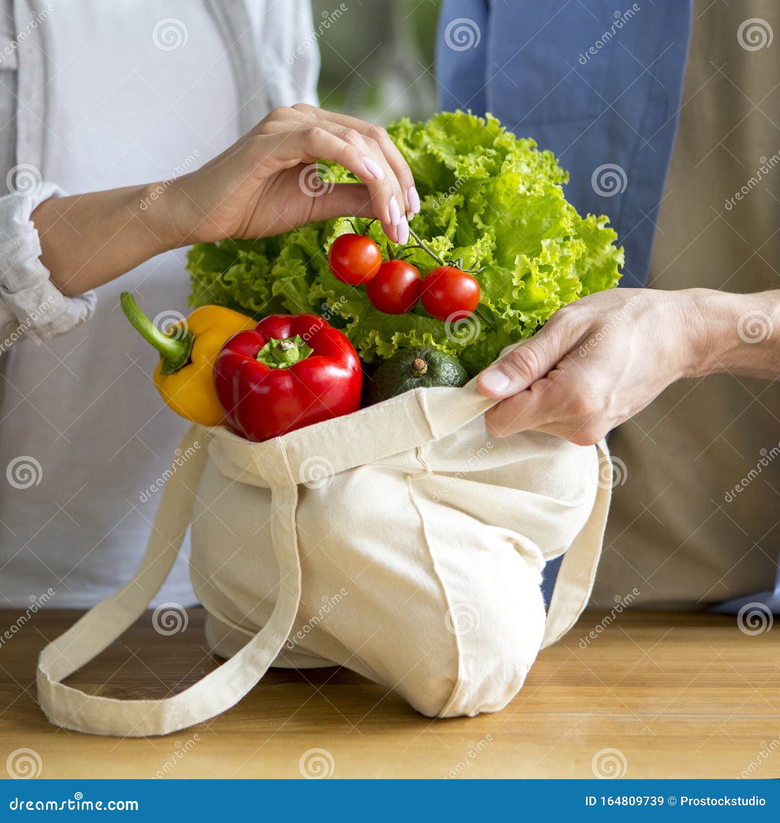couple of vegans using eco vegetables and reusable shopping bag