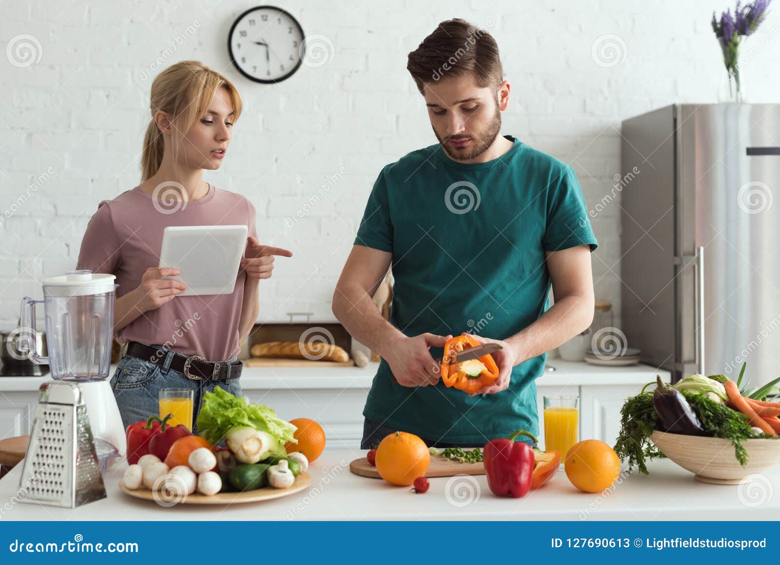 couple of vegetarians using tablet with recipe for cooking