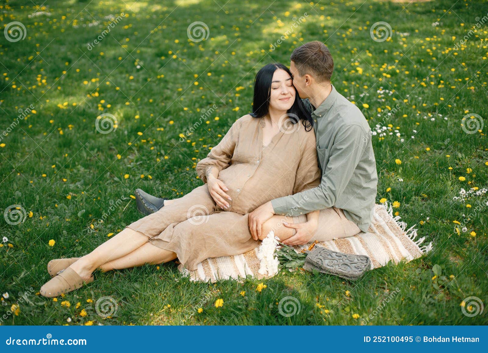 Pregnant Woman And Her Husband Sitting In A Park On A Grass And Hugging Stock Image Image Of 