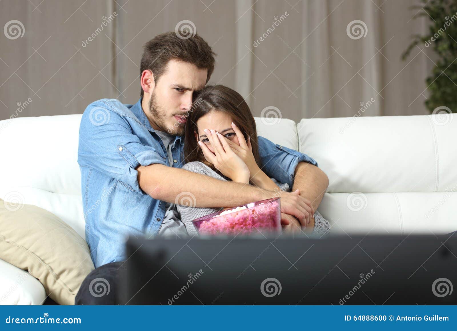 couple watching terror tv movie at home