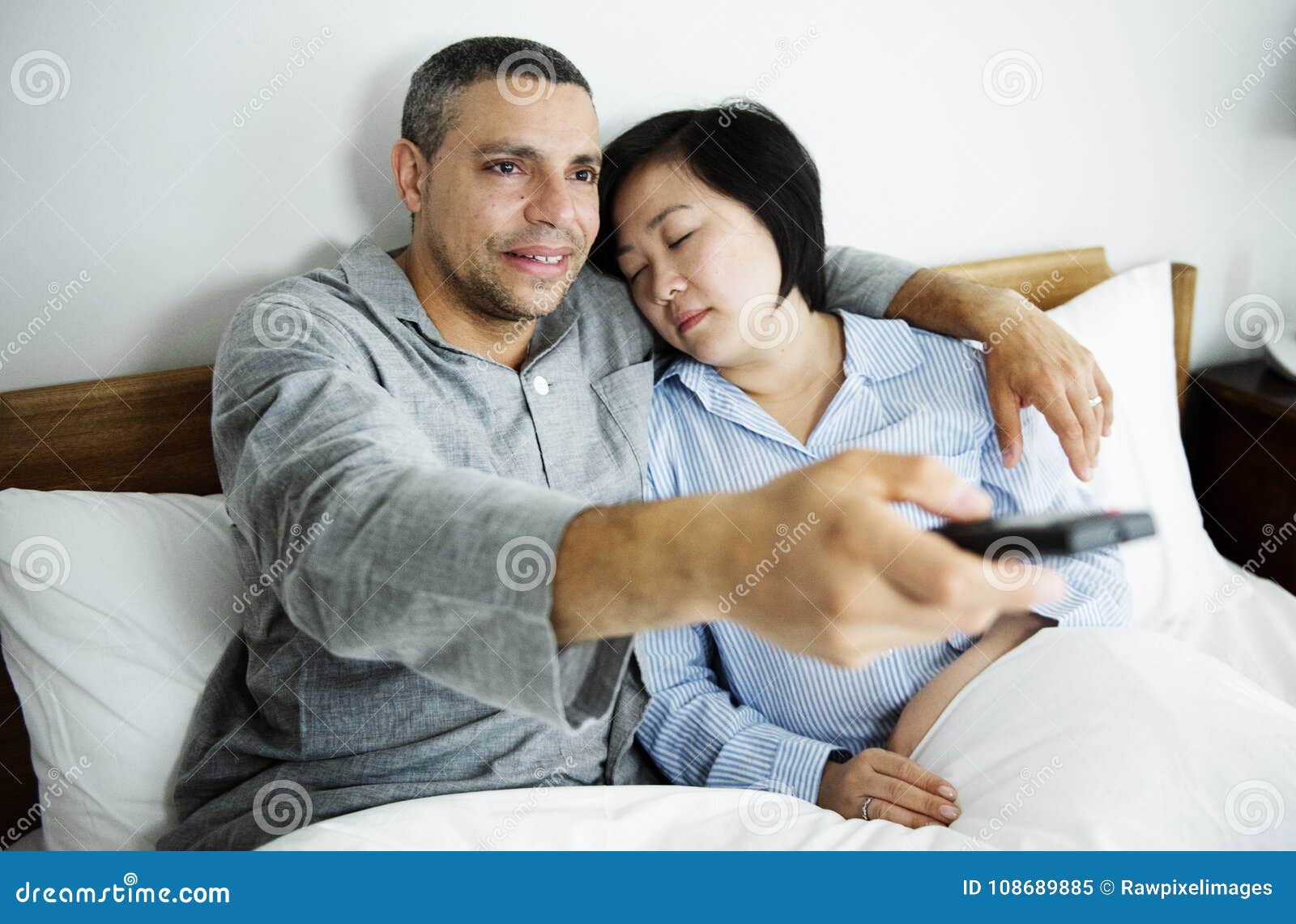 A Couple Watching Tv Together in Bed Stock Image Image of bedding