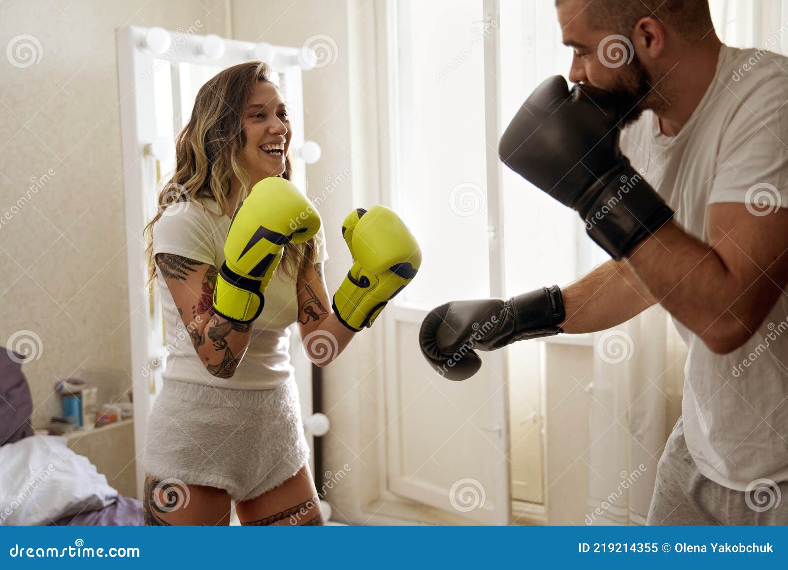 Couple Wearing Gloves Laughing while Having Boxing Training at Home Stock Image