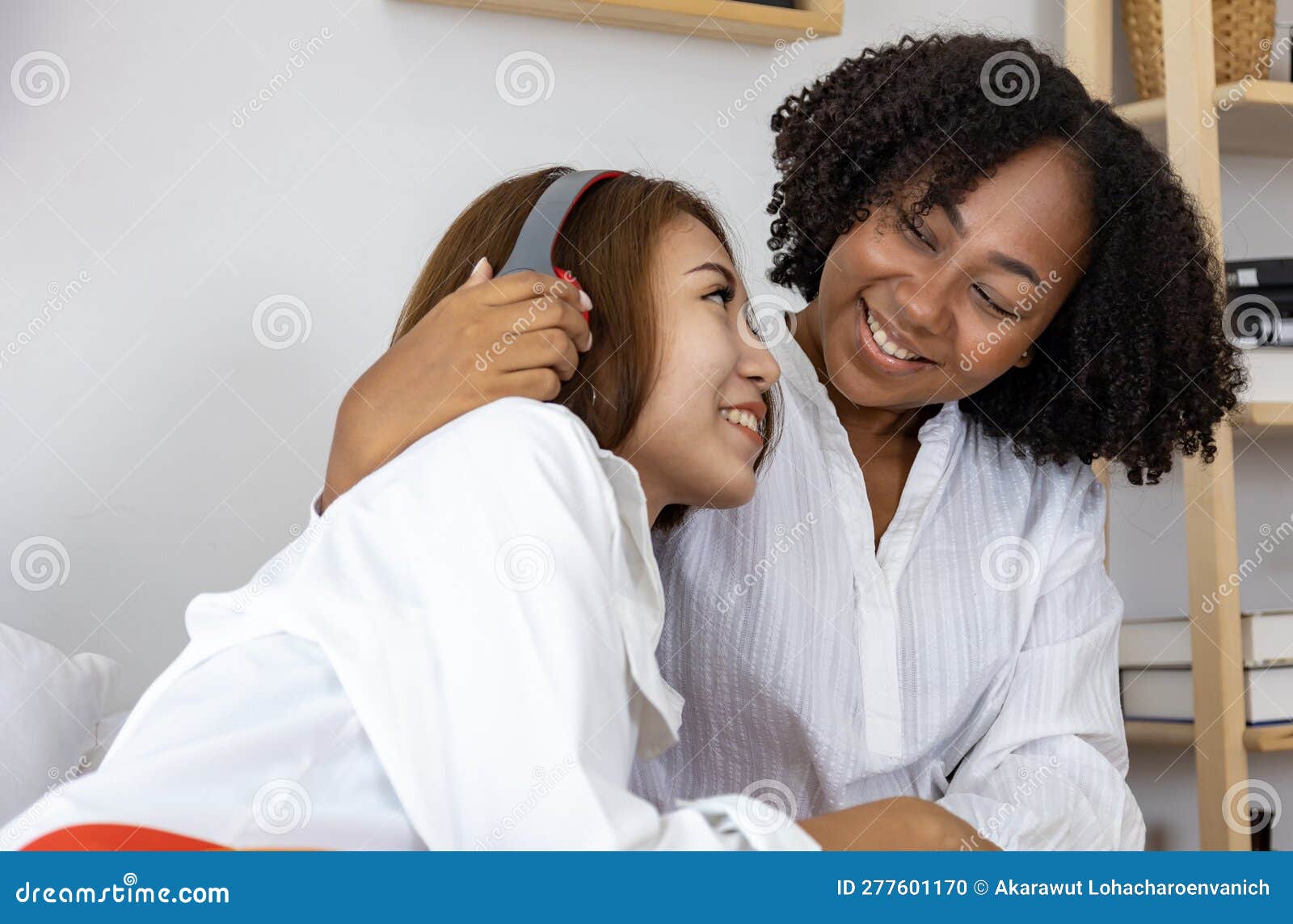 Couple Woman of Same Sex Marriage from Difference Races Having Lovely Time Together for Pride Month while Lying Down on Bed To Stock Photo