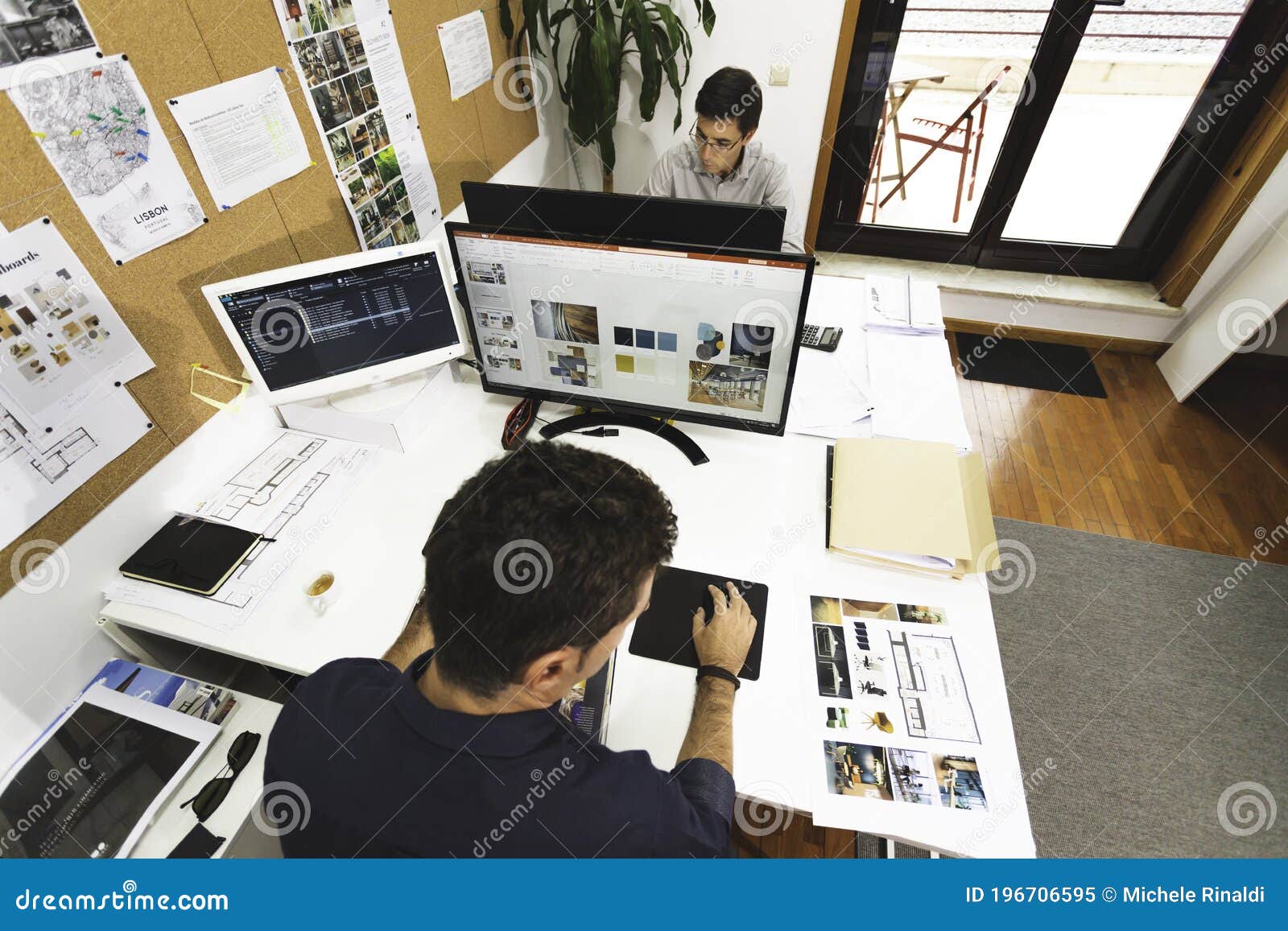 a couple of young male architect working smart from the office elaborating projects and s. two young man working on a