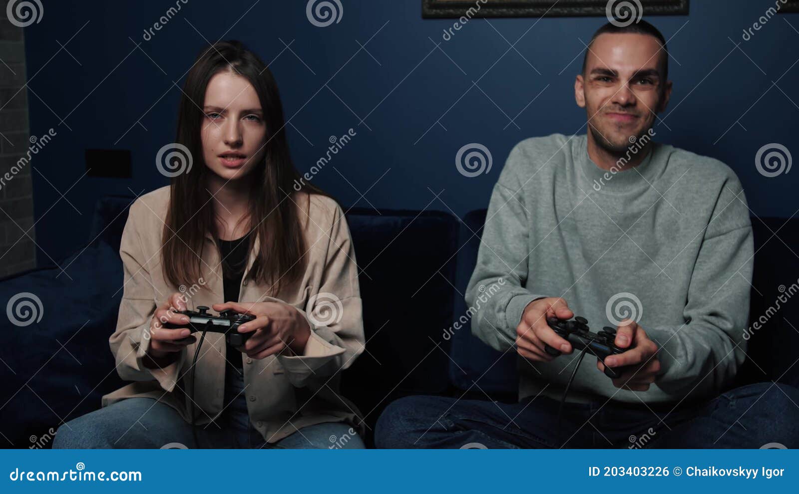 Couples Amateurs De Jouer Aux Jeux Vidéos Tout En Reposant Sur Le Canapé Devant La Télé à La Maison image