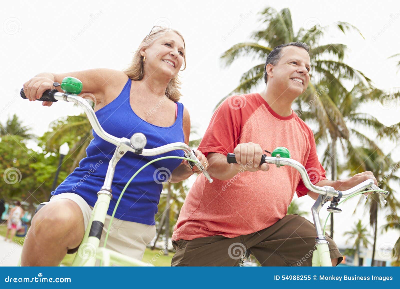 Couples supérieurs ayant l'amusement sur le tour de bicyclette