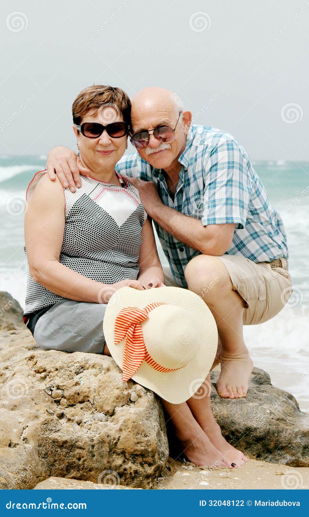 Couples supérieurs heureux marchant ensemble sur une plage