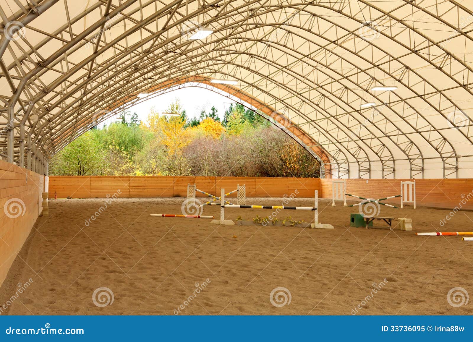 covered open horse arena with sand.