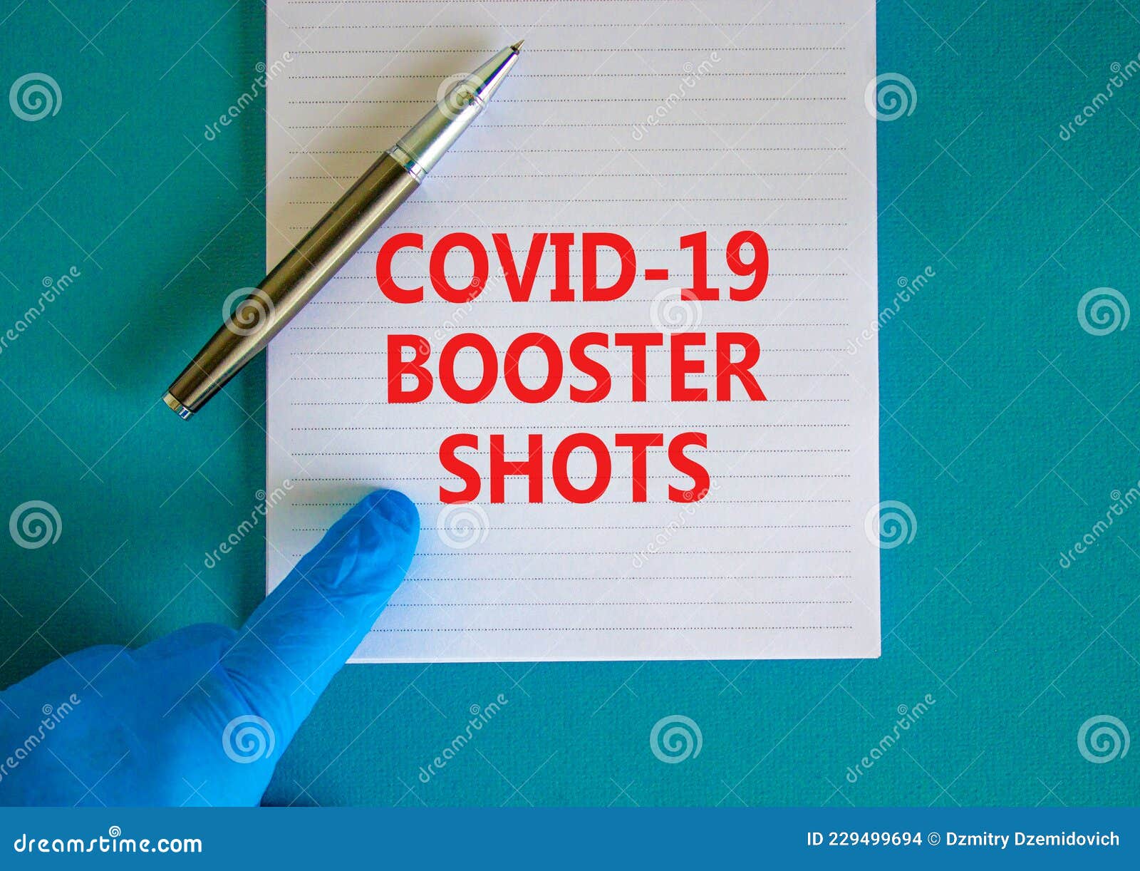 Covid-19 booster shots vaccine symbol. White note with words Covid-19 booster shots, beautiful blue background, doctor hand and metallic pen. Covid-19 booster shots vaccine concept