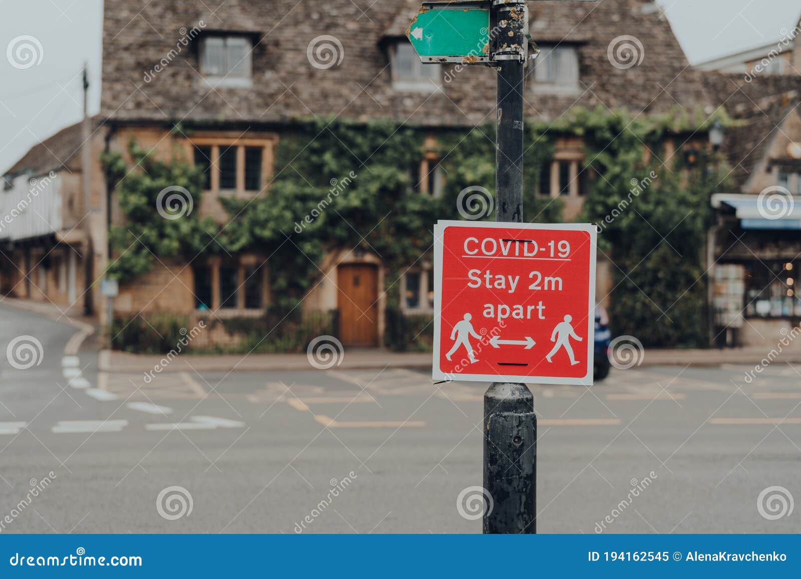 covid-19 stay 2 metres apart red sign on a street in bourton-on-water, cotswolds, uk