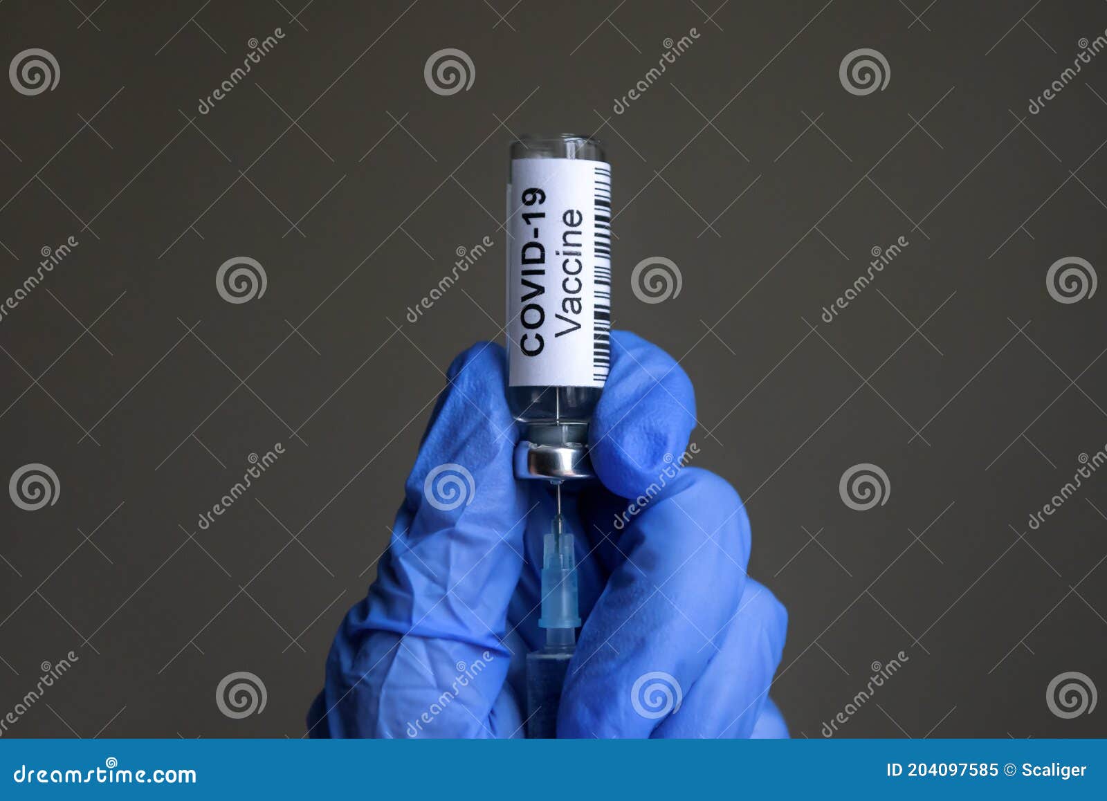 covid-19 vaccine bottle and syringe for coronavirus cure in doctorÃ¢â¬â¢s gloved hands