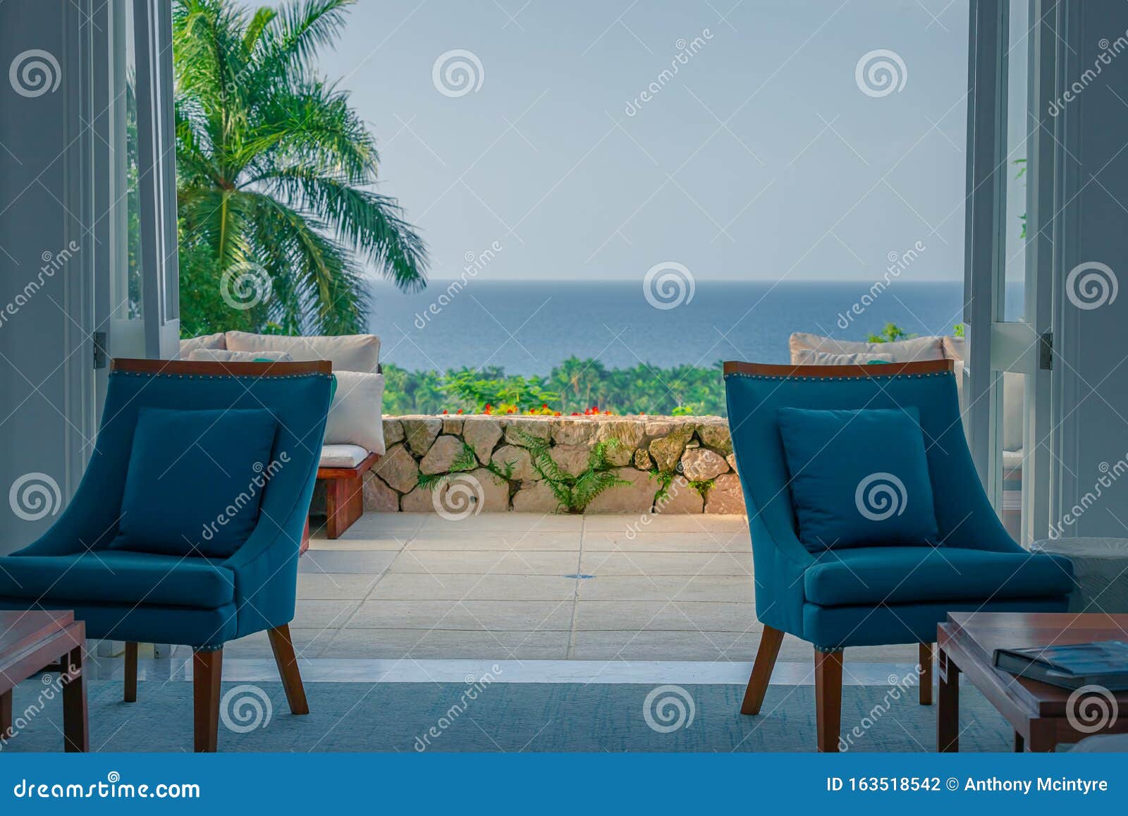 Cozy Chairs Inside of a Beach House with Open Doors Leading To Palm Trees  and the Ocean Stock Photo - Image of exterior, modern: 163518542