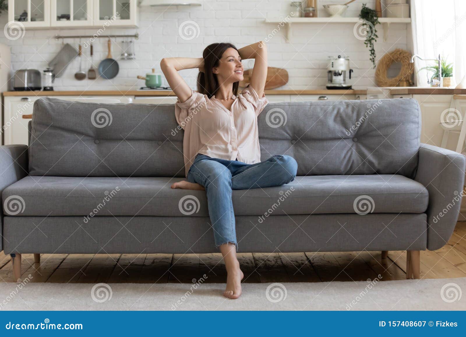 in cozy living room happy woman sitting on couch alone