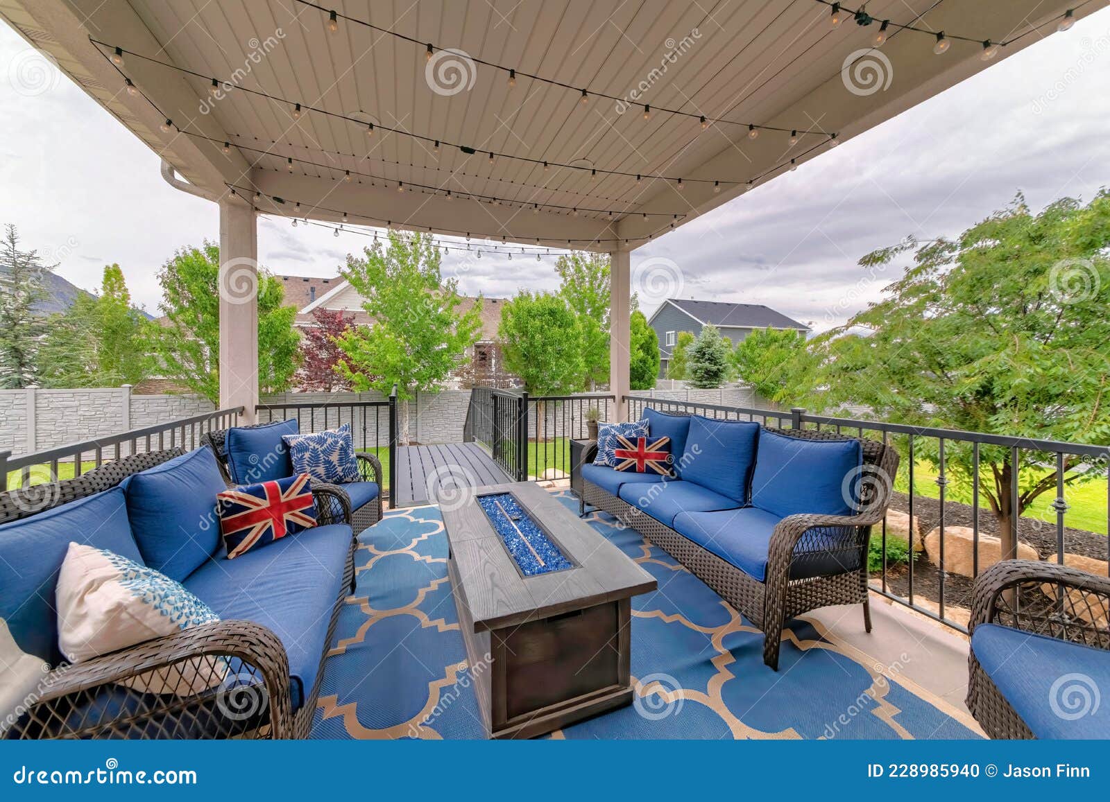 Cozy Outdoor Deck with Fire Pit Table and Woven Sofas with Blue