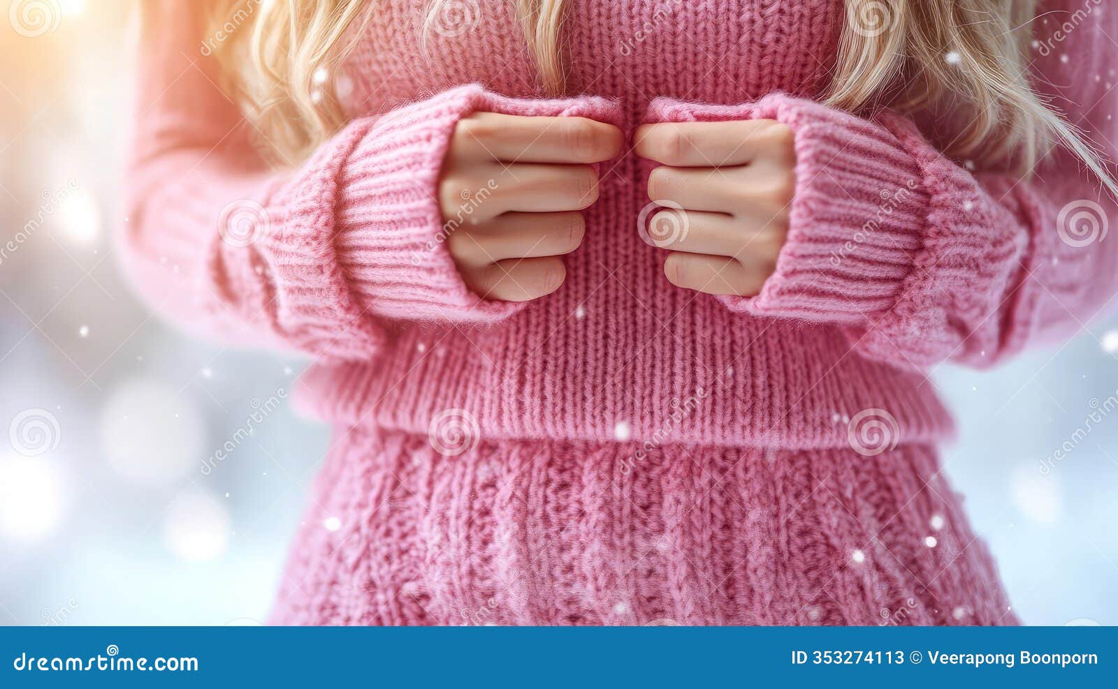cozy pastel pink sweater hugs the models hands in a serene winter wonderland scene
